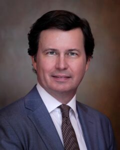 Man in suit with brown background.